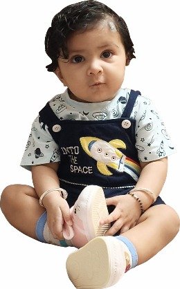 A baby sits wearing a space-themed outfit with a rocket and Into the Space text, white shoes, and a short haircut.